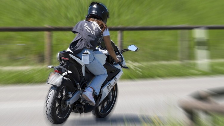Motorradfahrerin fährt ohne Schutzkleidung